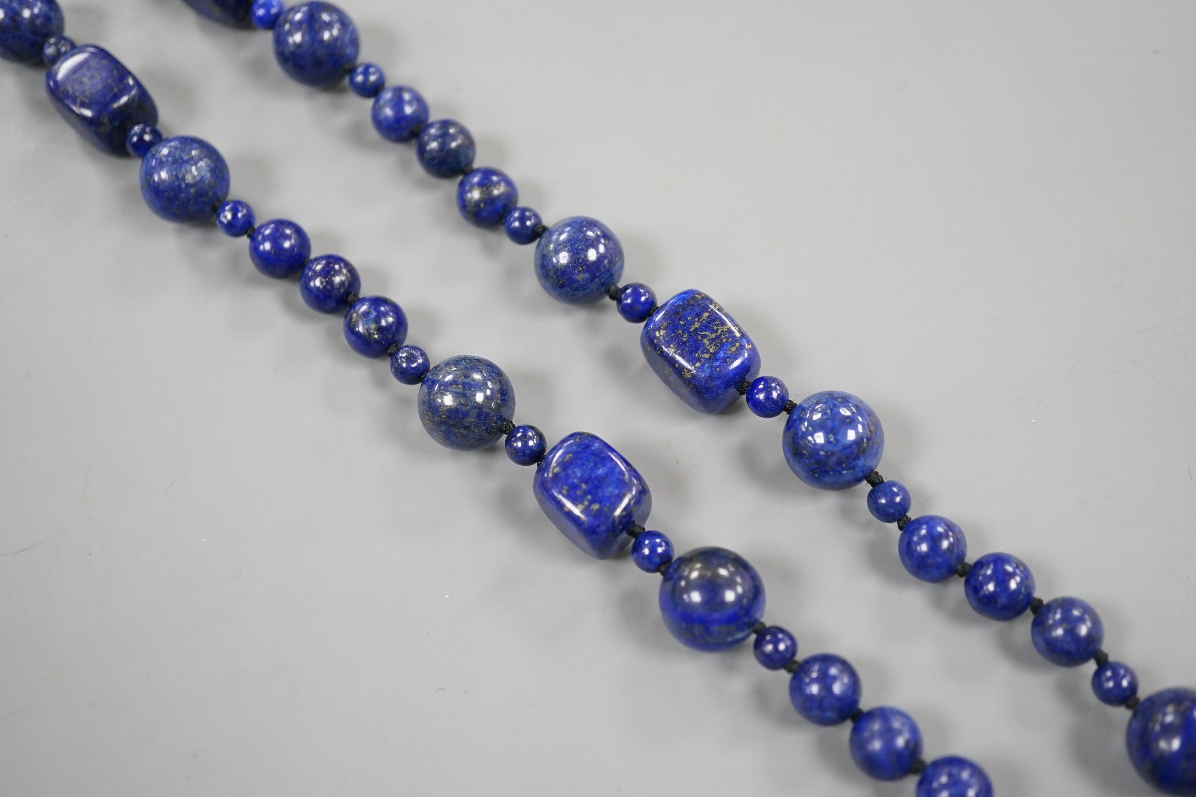 A single strand lapis lazuli round and barrel bead necklace, 72cm.